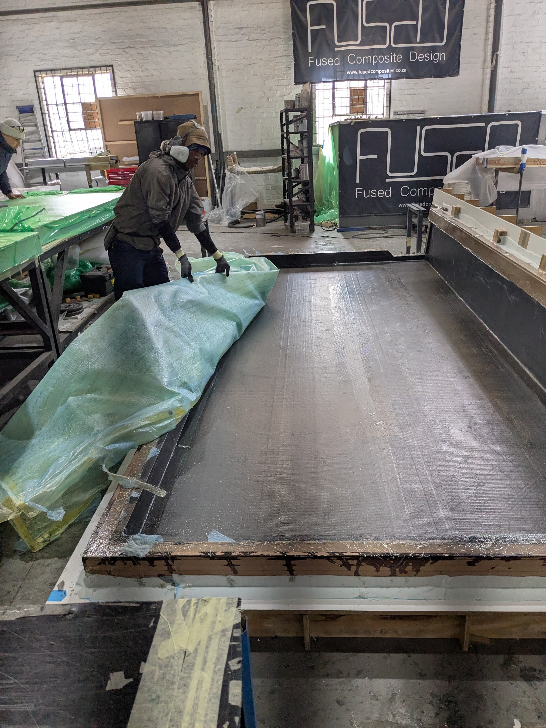 Dry carbon fabric laid along a long tool in the FCD workshop