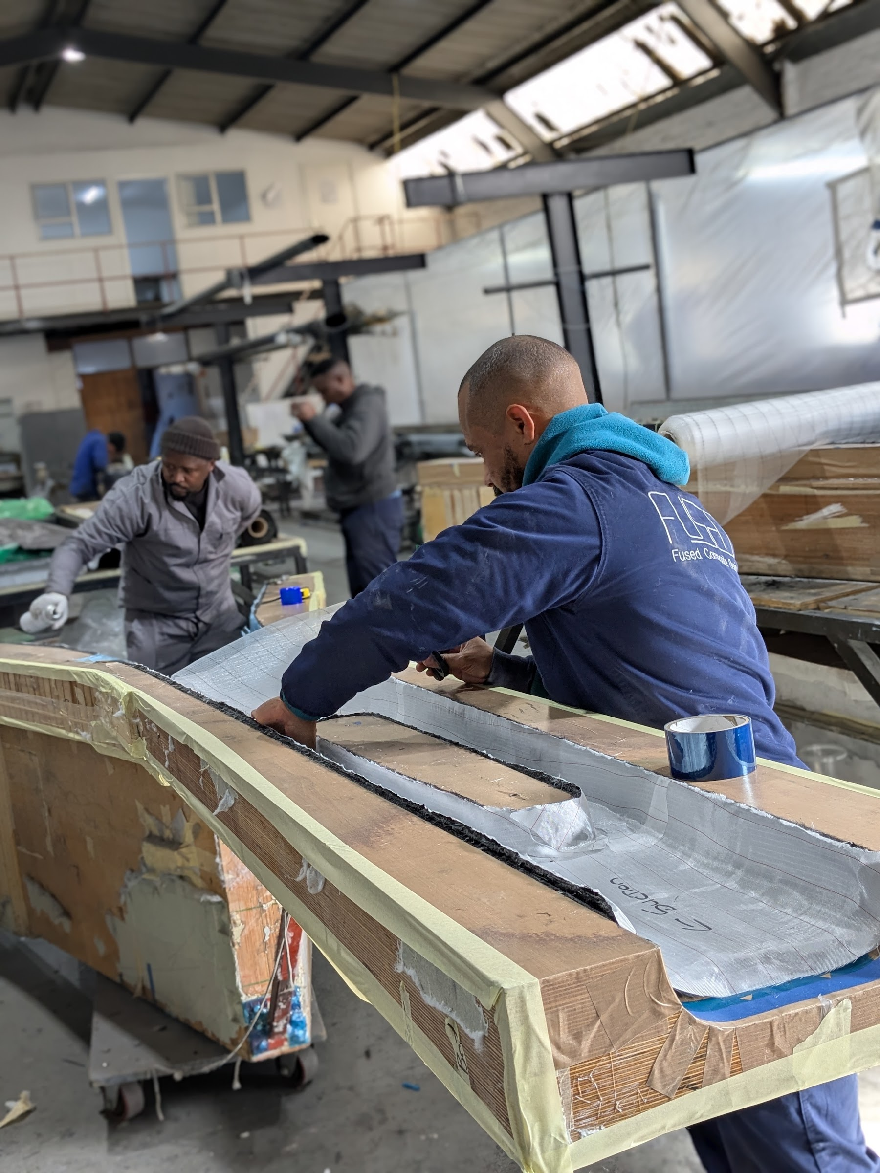 Technician finishing a laminate at the mould flange in the FCD workshop