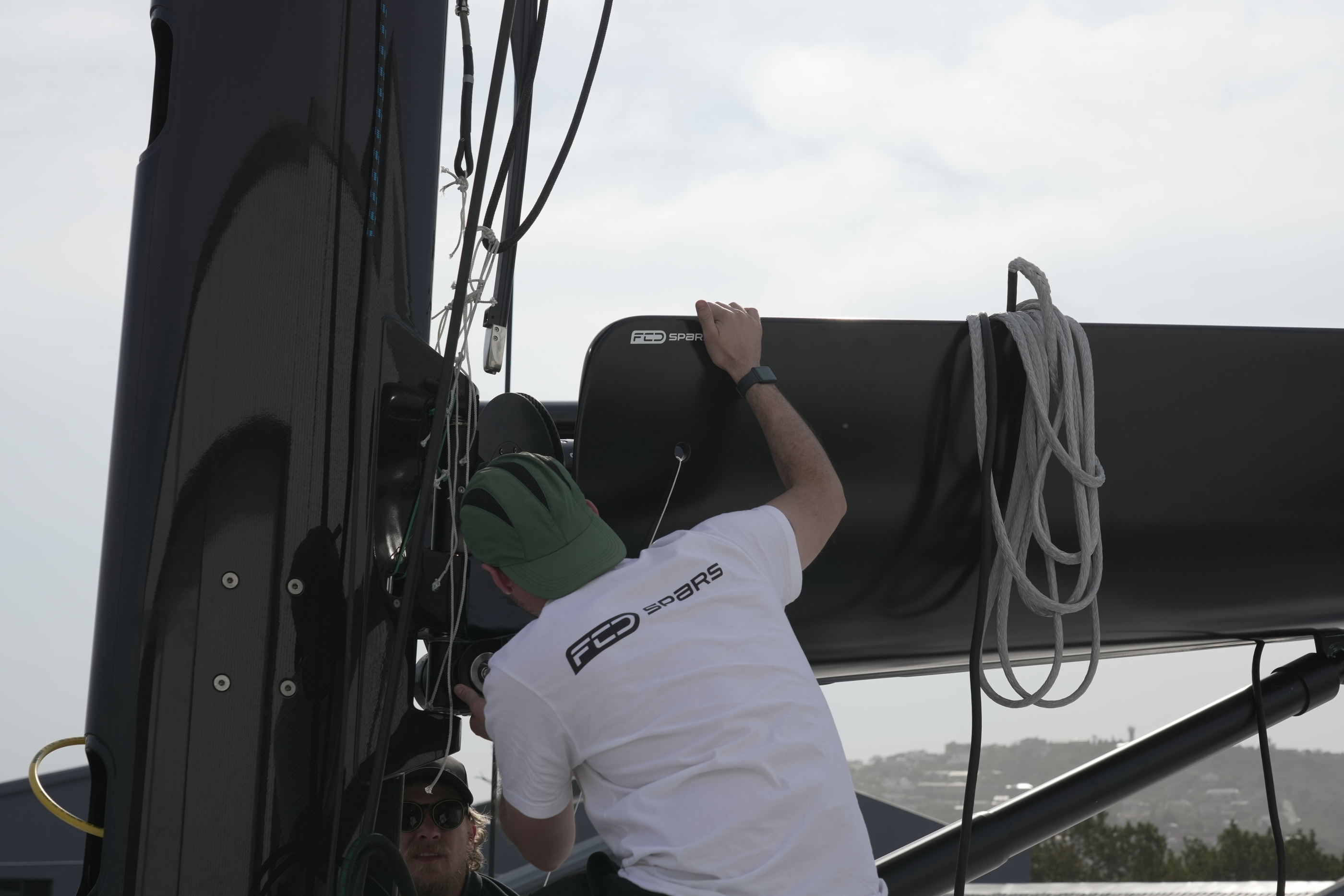 FCD installation technician fitting a furling boom to the mast
