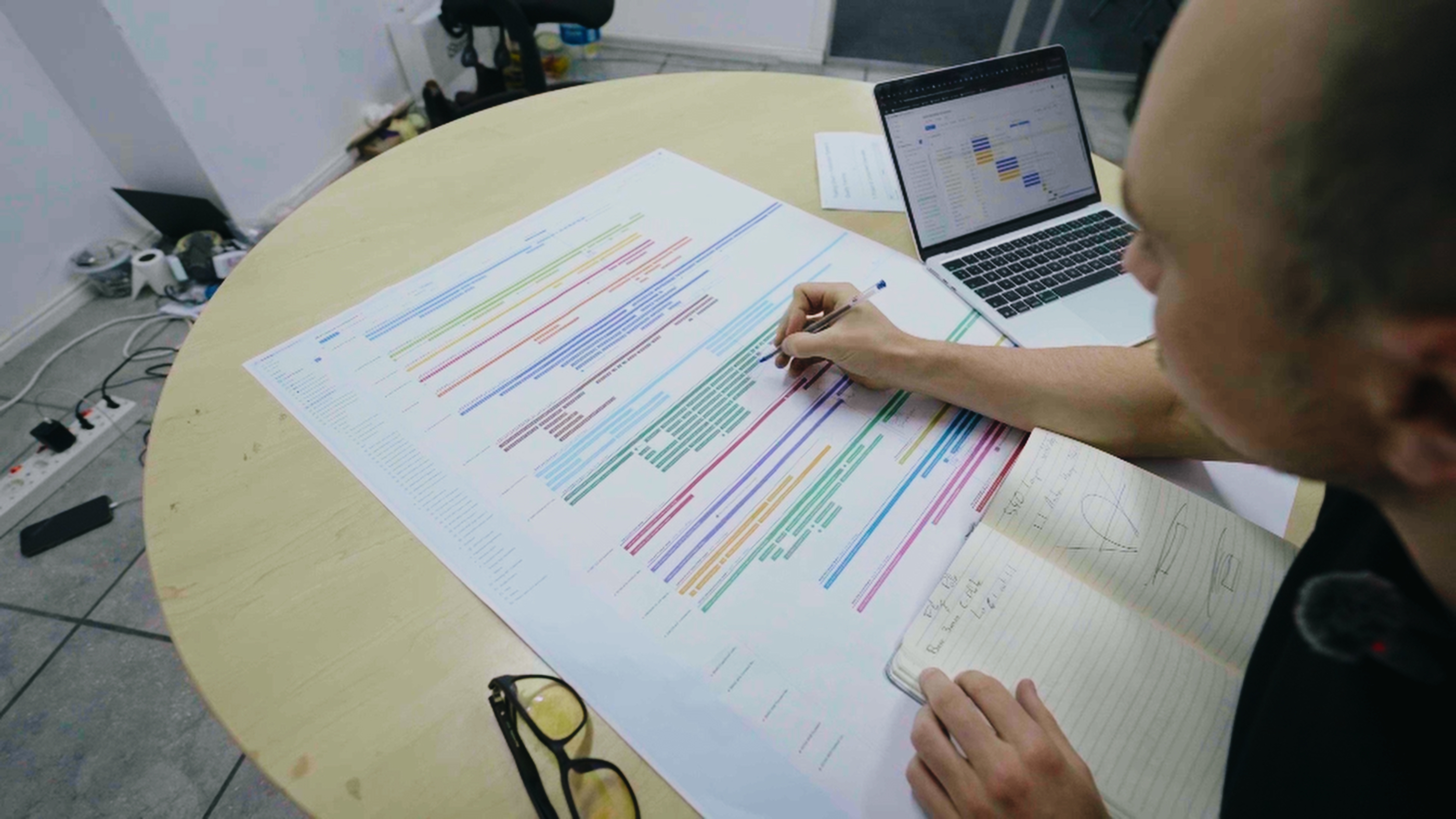 Engineer reviewing a printed production schedule across several projects