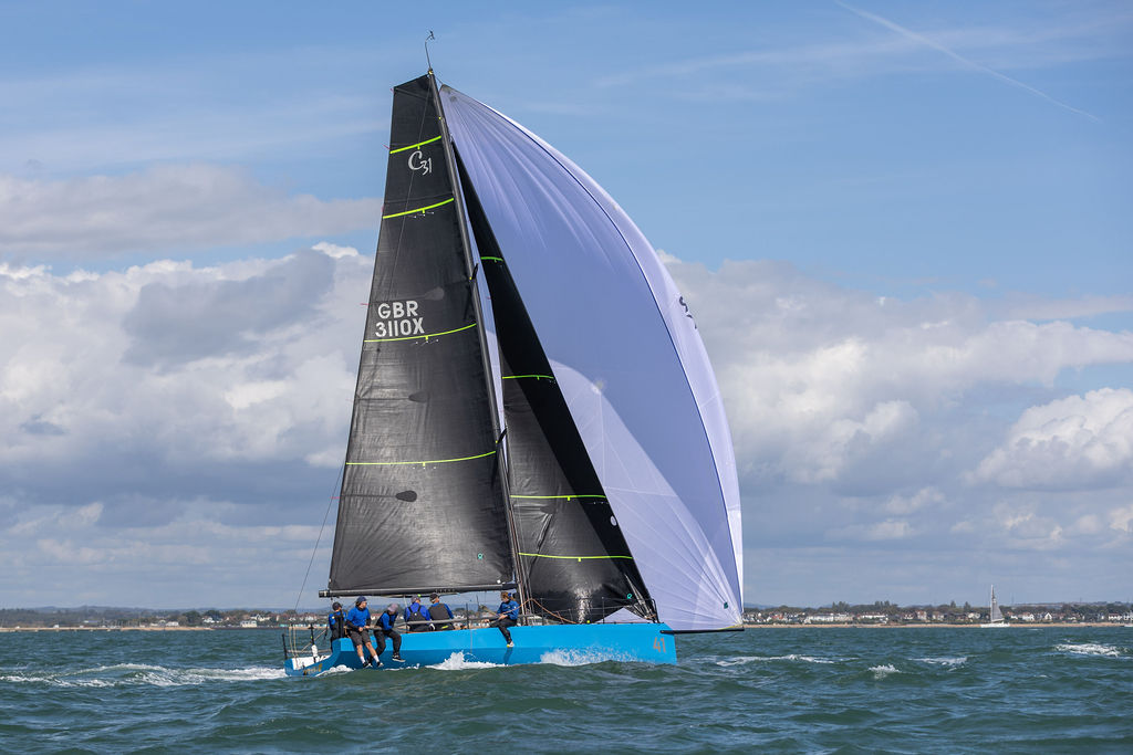 Cape 31 sailing under spinnaker, full carbon rig in profile