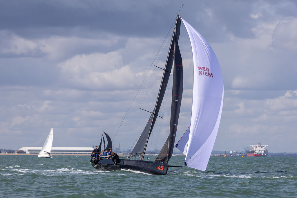 Cape 31 reaching under spinnaker on grey water