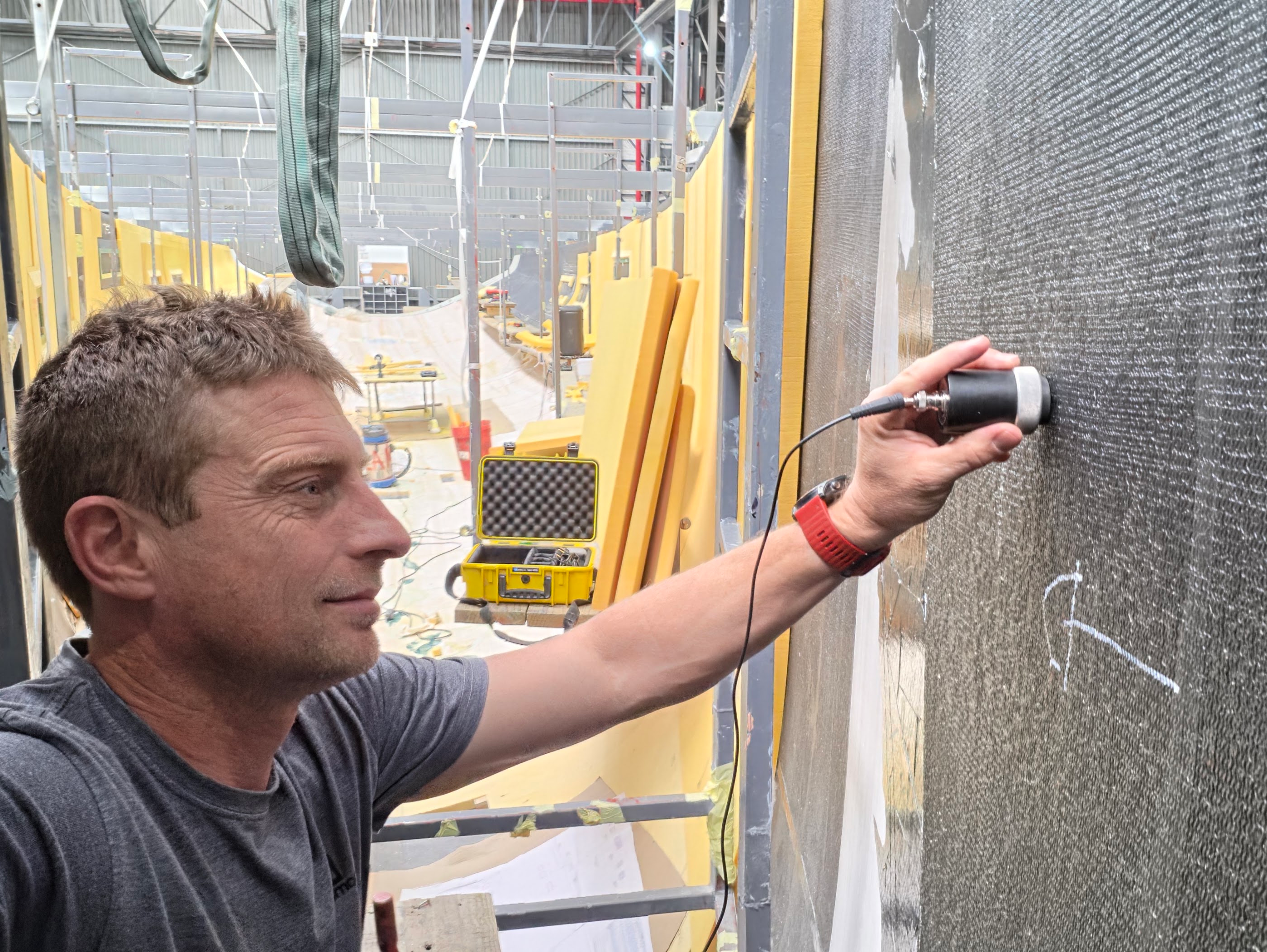 Engineer running an ultrasound NDT probe over a carbon laminate.